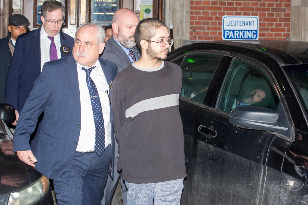 Police officers are seen walking with Justin Herde after he was charged with the murder of William Alvarez on a Bronx D train.