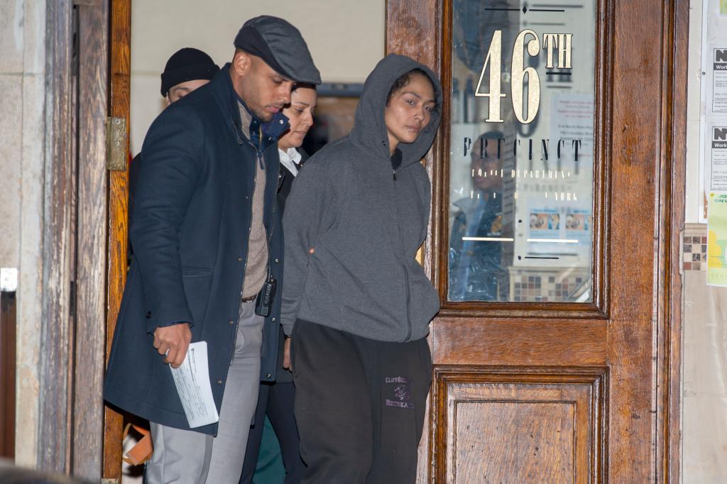 Police officers and EMT's remove Betty Cotto from the precinct after being were charged with the murder of William Alvarez.