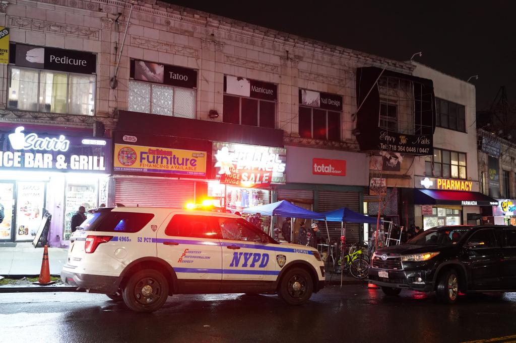 NYPD car parked in front of storefronts in the Bronx. 