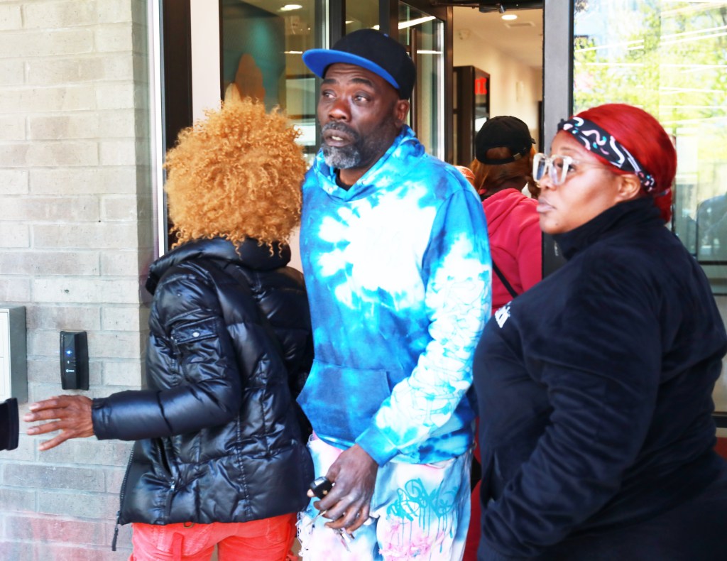 Robinson's family members outside the building where he was mauled to death by a pit bull.