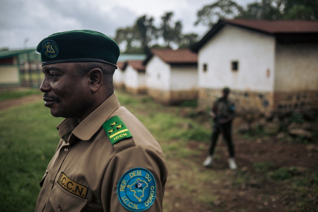 De-Dieu Bya'Ombe Balongelwa, Chief of Kahuzi-Biega National Park, stands in the courtyard of the park headquarters flanked by his armed escort on September 30, 2019.