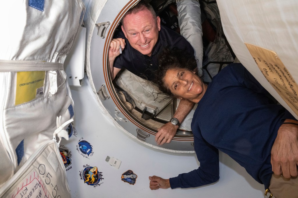 Boeing Crew Flight Test astronauts Butch Wilmore, left, and Suni Williams pose for a portrait inside the vestibule between the forward port on the International Space Station's Harmony module and Boeing's Starliner spacecraft