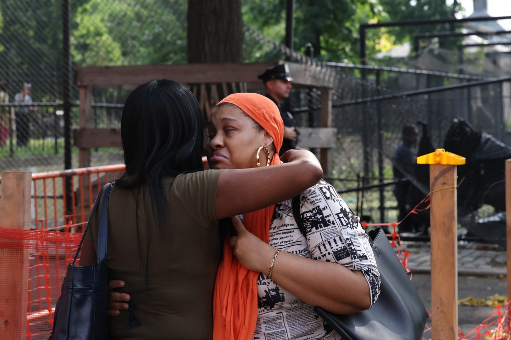 Haneefah Hadsan, a woman hugging another woman, at the scene of a fatal motor vehicle accident in Corleone Hook Park on 4th of July