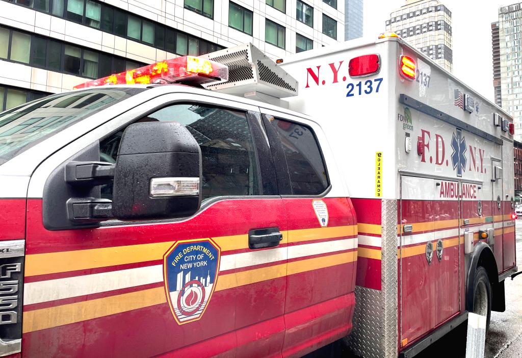 FDNY ambulance with lights flashing responding to an emergency and waiting to transfer patient to a hospital for medical care.