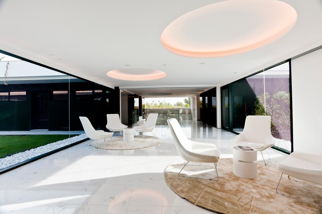 A room with white chairs and a round rug in the SHA Wellness Clinic Spa