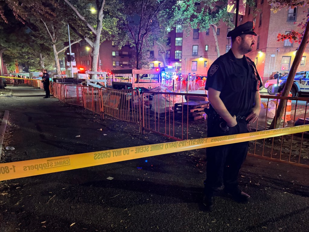 Truck crashed into a park with people stuck under it and police officer standing in front of a barricade at Jackson and Water Street in Manhattan