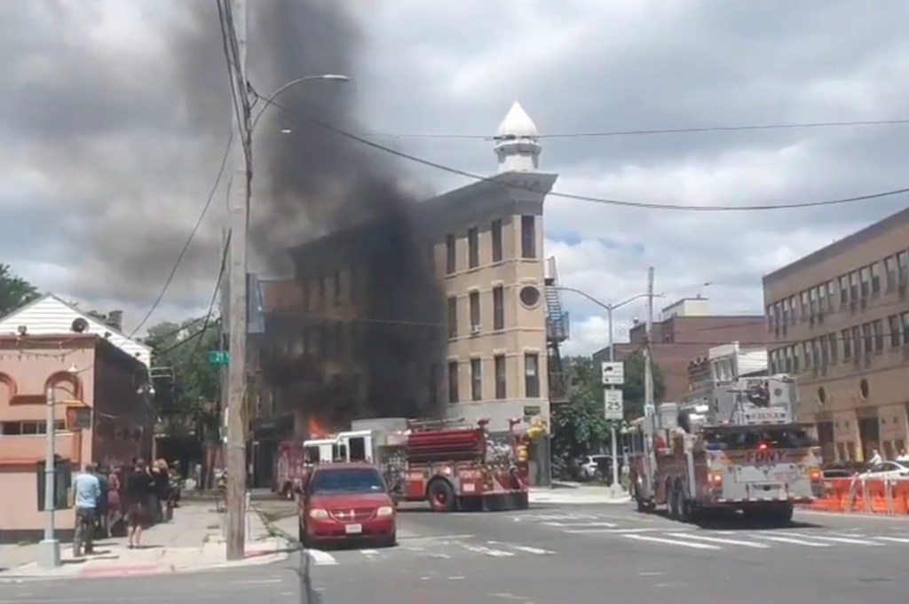 Video grab showing smoke coming from a burning ice cream truck with fire trucks attending to the accident