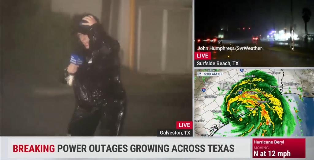 Weather channel reporter in a black suit reporting live from Galveston amidst powerful gusts and torrential rains caused by Hurricane Beryl