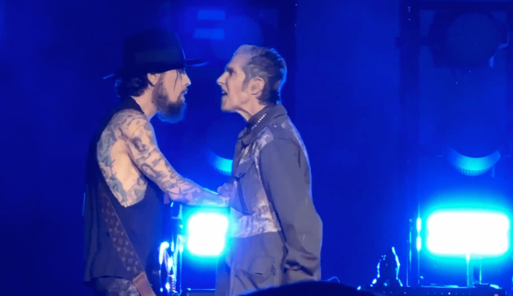 Jane's Addiction frontman Perry Farrell punched guitarist Dave Navarro during an on-stage outburst as several crew members dragged him off stage and abruptly ended the Boston concert on Friday night.