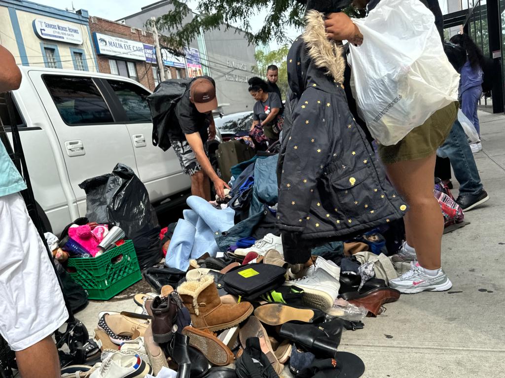 People selling goods on the sidewalk near Roosevelt Avenue and 91st Street in Queens on Sept. 1, 2024.