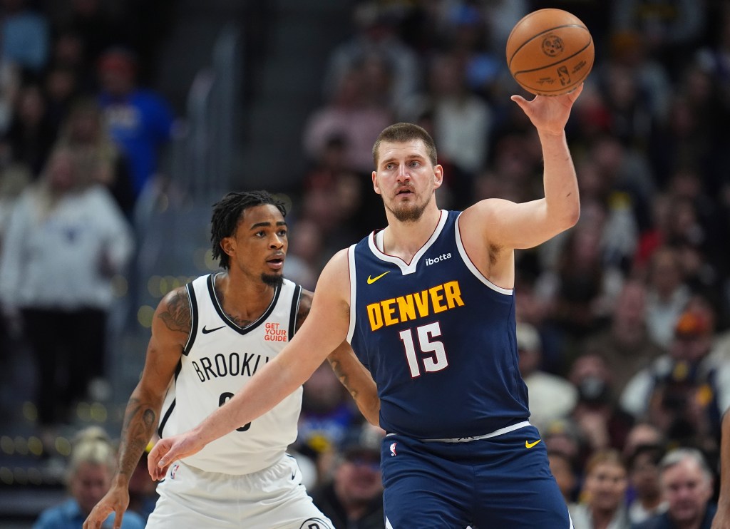 Denver Nuggets center Nikola Jokic, front, fields a pass as Brooklyn Nets center Nic Claxton defends in the first half of an NBA basketball game Friday, Jan. 10, 2025, in Denver.