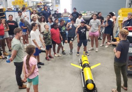 WHOI Senior Engineering Assistant Diana Wickman discusses the operation of an OOI ocean glider with Mashpee Wampanoag POH visitors. Photo credit J. Lund.