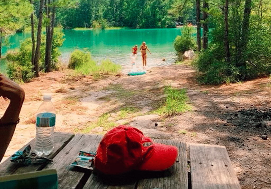 Image shows two women walking into the naturally lush blue lagoon in Houston.