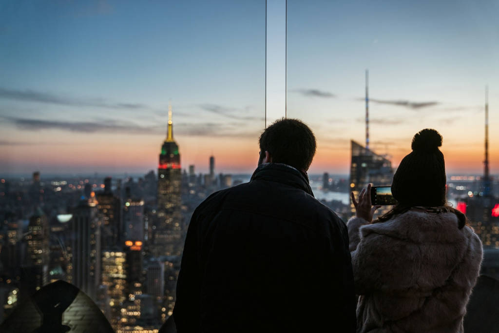 A couple looking at the NYC skyline at sunset