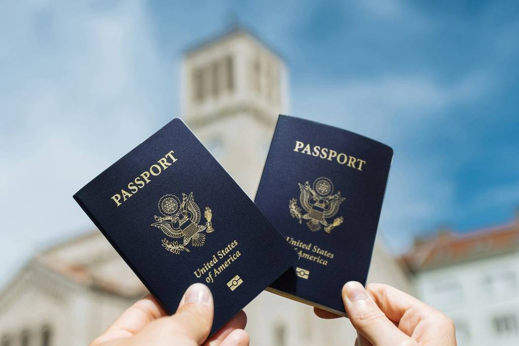 Two people holding up their United States passports