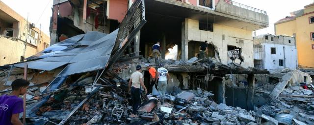 Lebanese people search for their belongings in a damaged building after Israeli strikes on South Lebanon on 23 September, in the village of Al Aqbieh near Sidon, South Lebanon.