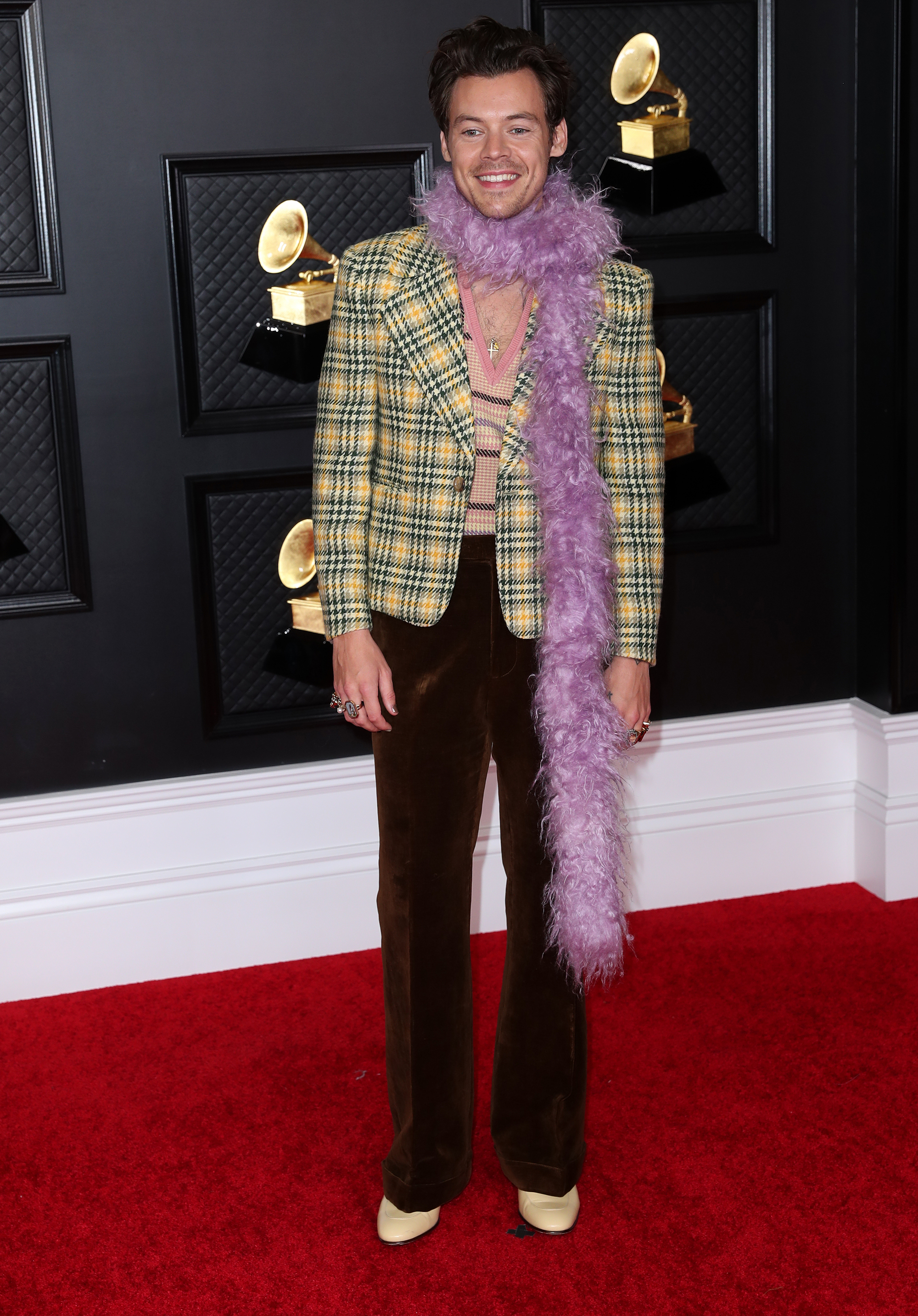 Harry Styles hit the Grammys 2021 red carpet in a Gucci look topped off by a purple feather boa.