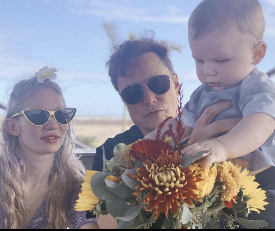 Grimes and Musk's son reaches for flowers in photo shared via X.