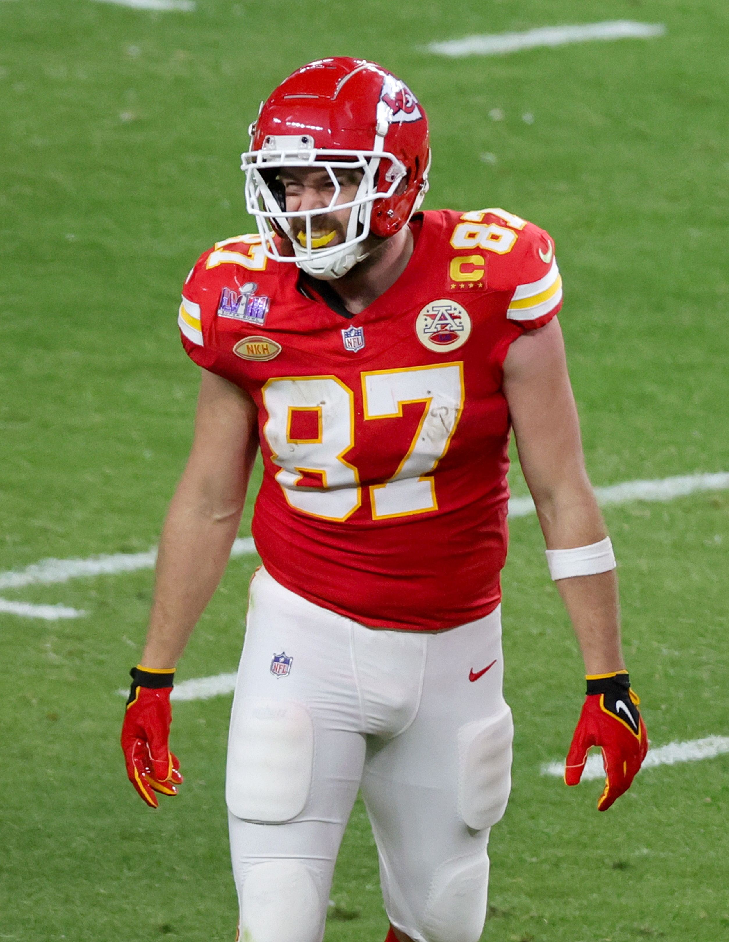 Travis Kelce on a football field and in uniform.