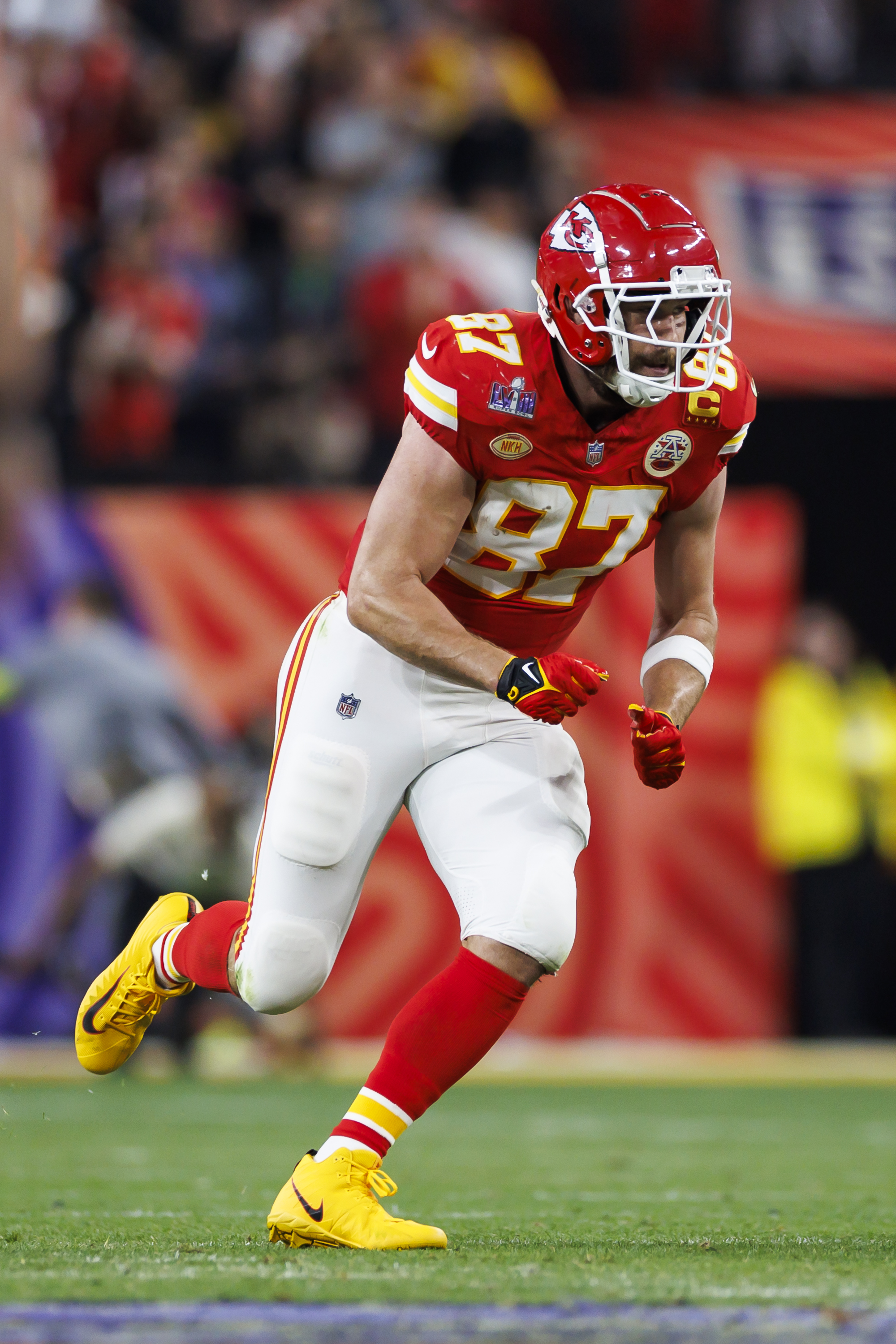 Travis Kelce on a football field and in uniform.