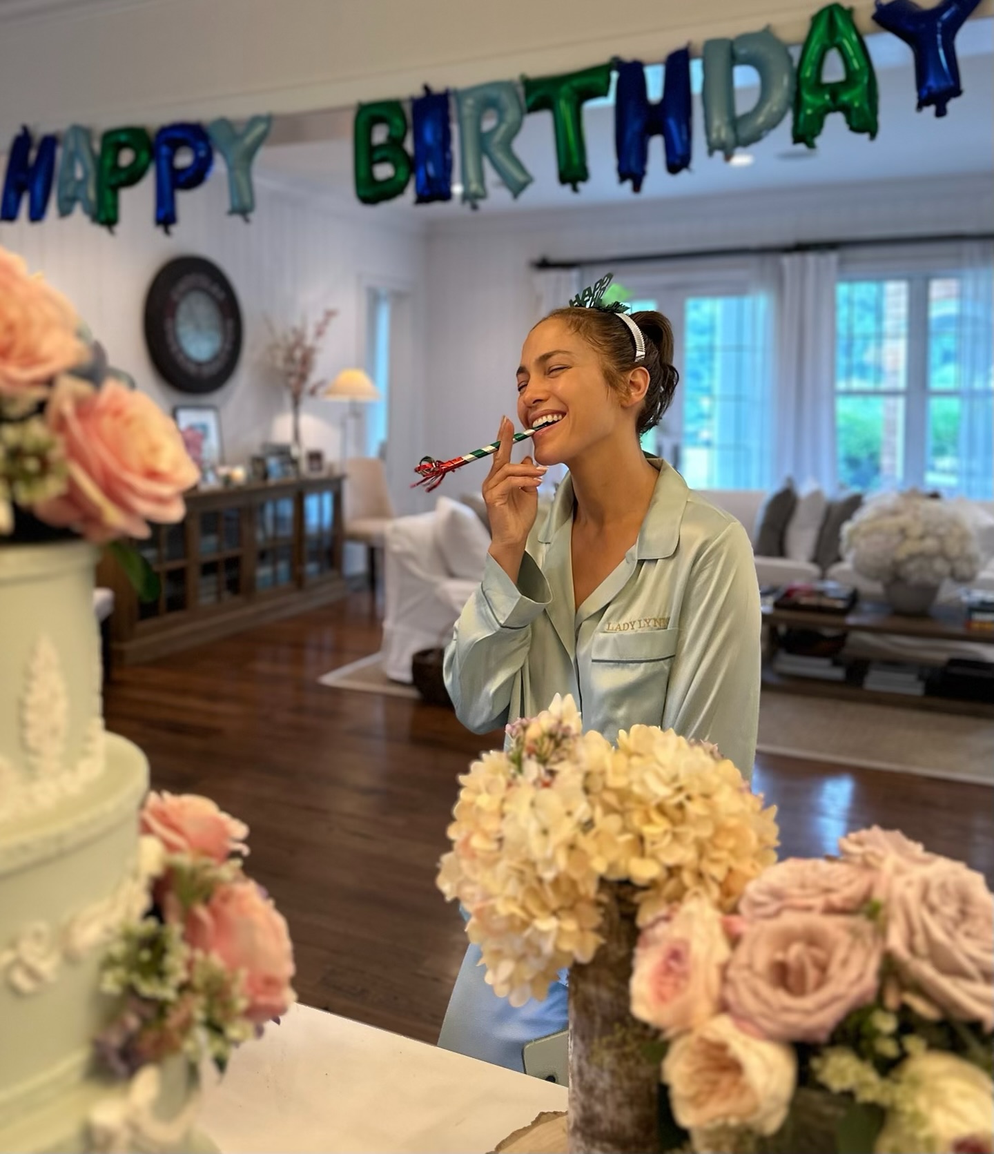 Jennifer Lopez poses on her birthday with a cake.