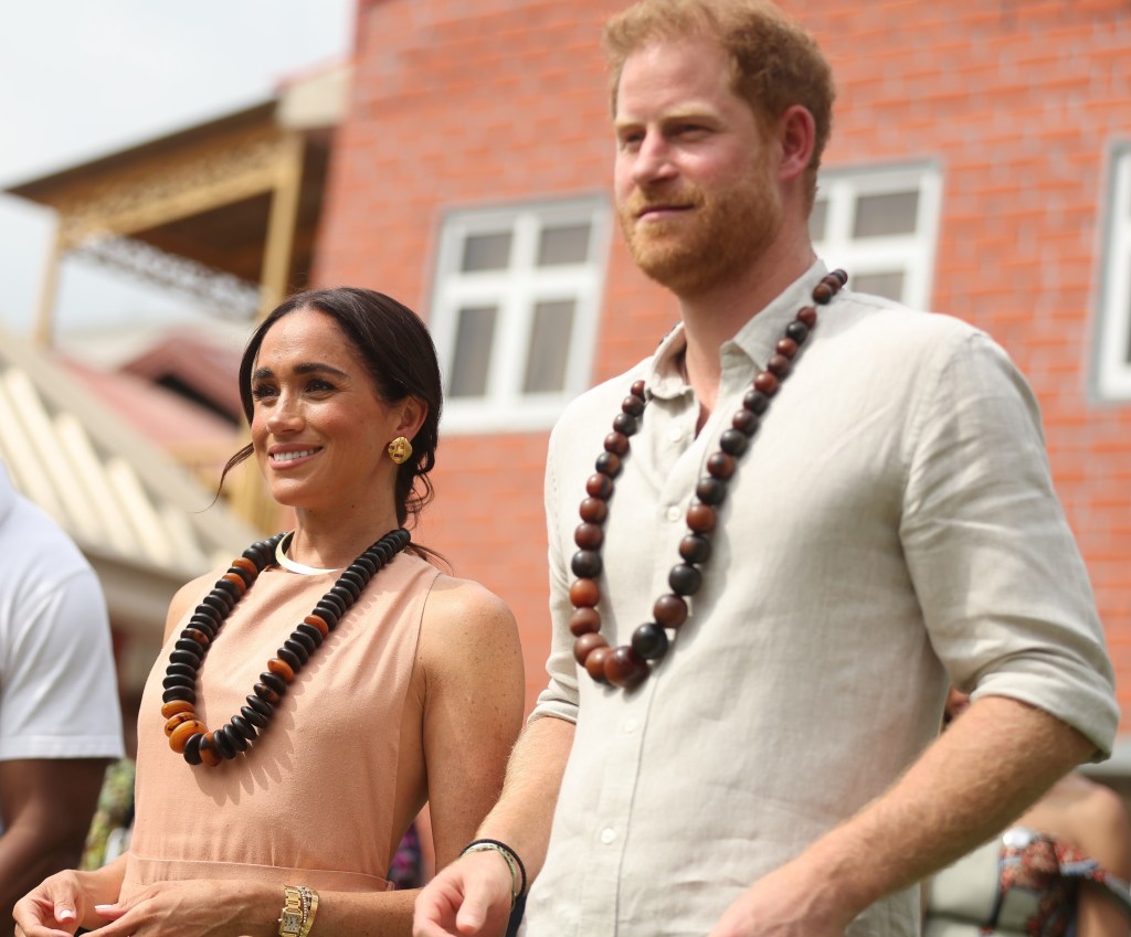 Prince Harry and Meghan Markle wear wooden beads on tour in Nigeria.