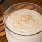 closeup of a glass of Almond banana cinnamon smoothie on a wood table