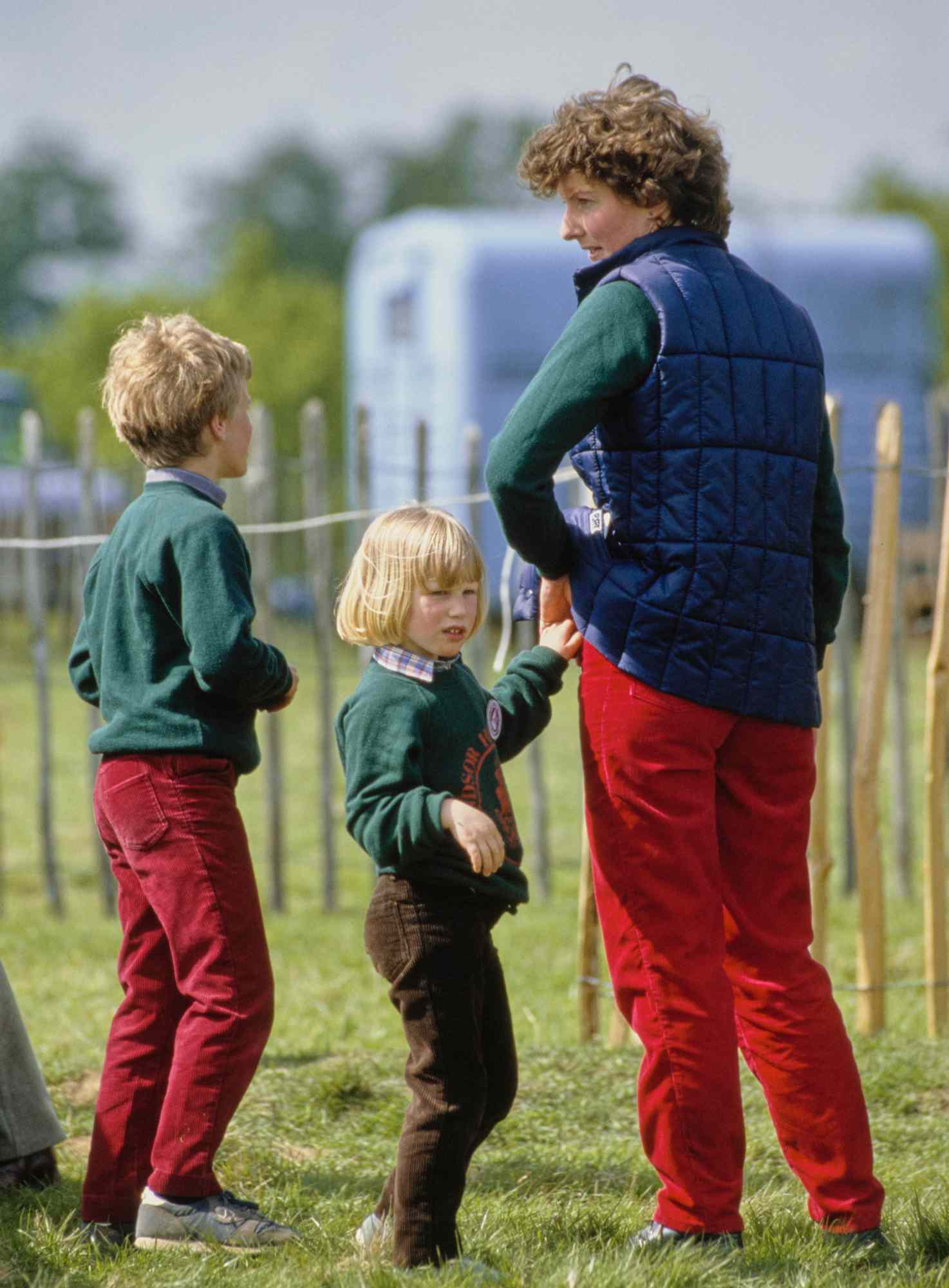 Peter Phillips and his sister Zara Phillips, wearing matching Windsor Horse Trials sweatshirts, with their nanny, Sarah Minty, at the Royal Windsor Horse Show, held at Home Park in Windsor, Berkshire, England, 12th May 1984