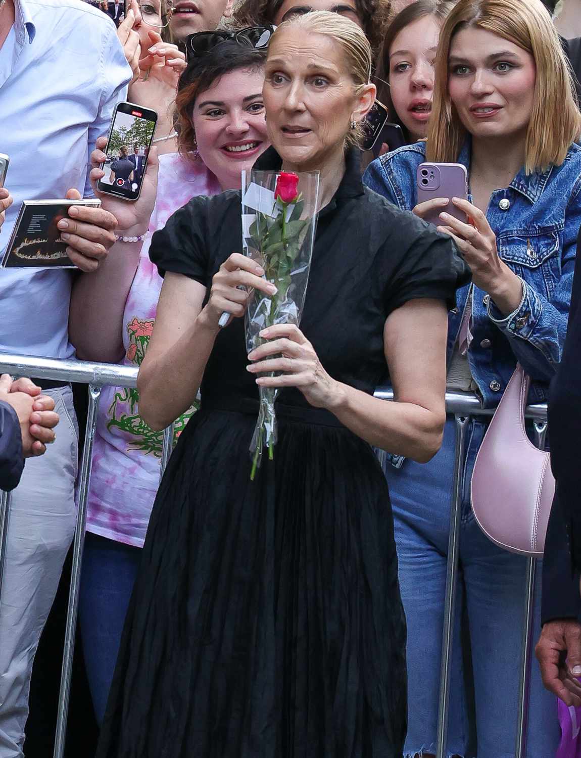 Celine Dion leaves her hotel in Paris, greeted by cheering fans who offered her a rose.