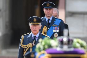King Charles III and Britain's Prince William, Prince of Wales walk behind the coffin of Queen Elizabeth II, adorned with a Royal Standard and the Imperial State Crown
