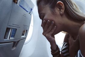 Stock photo of woman feeling sick and scared on airplane