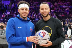 Seth Curry #31 of the Philadelphia 76ers and Stephen Curry #30 of the Golden State Warriors pose for a photo with an NBA 75th Anniversary basketball prior to a game on December 11, 2021 at Wells Fargo Center in Philadelphia, Pennsylvania.