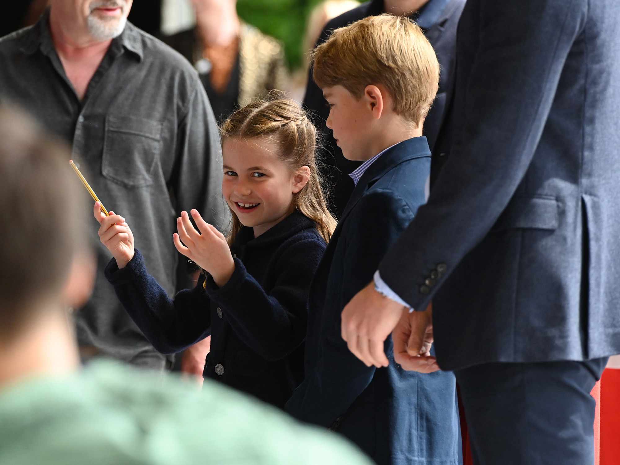 Princess Charlotte of Cambridge laughs as she conducts a band next to her brother Prince George of Cambridge during a visit to Cardiff Castle