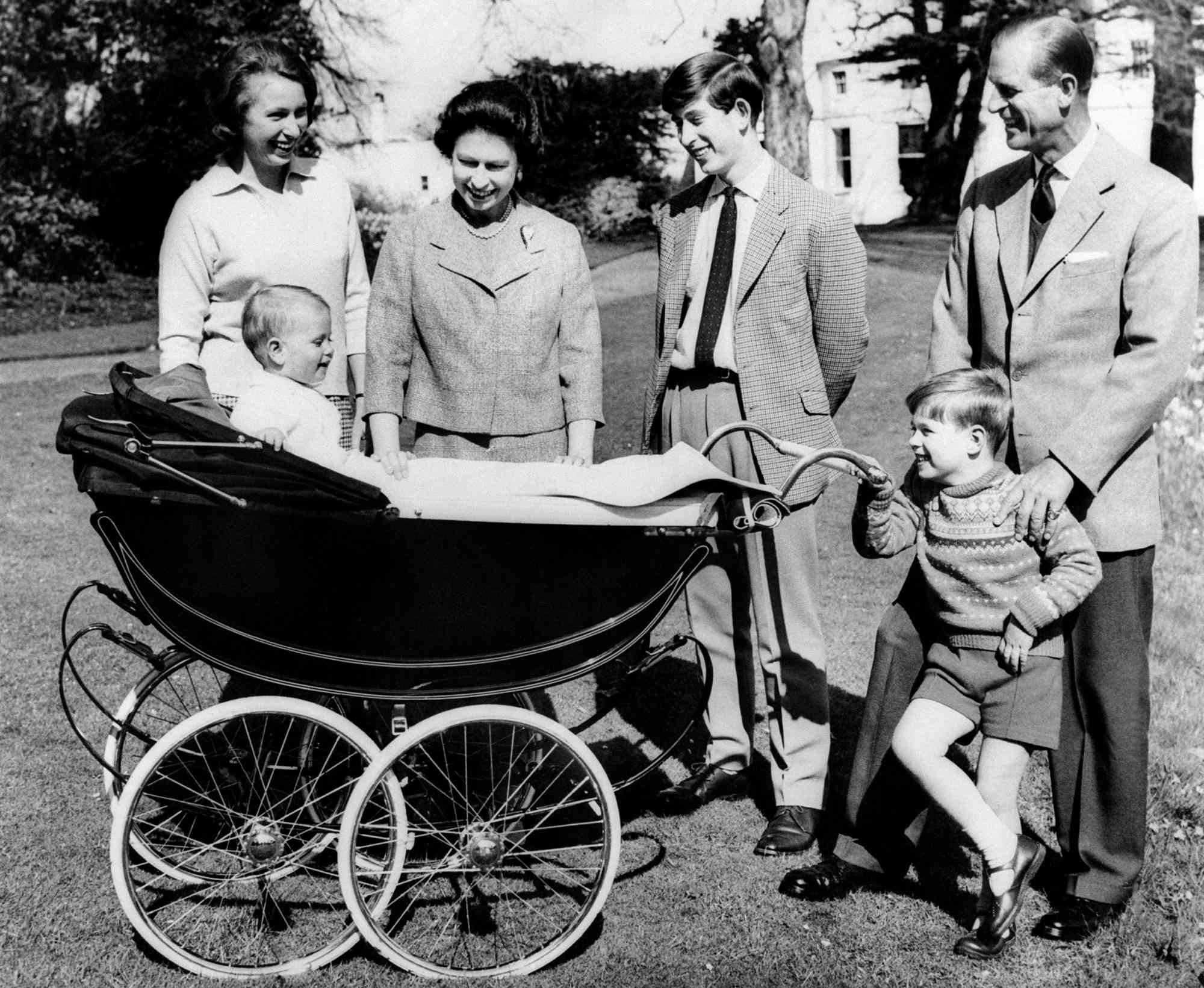 April 21, 1965 at Frogmore House in Windsor, Berkshire shows The British Royal Family: (from L to R) Princess Anne, Britain's Queen Elizabeth II, Prince Charles, Prince of Wales, Prince Philip, Duke of Edinburgh, Prince Andrew, Duke of York smiling at Prince Edward, Earl of Wessex, in his cradle