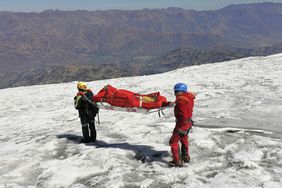 Undated handout picture released by Peruvian National Police on July 8, 2024, showing police officers evcacuating the body of US mountain climber William Stampfl, who was reported missing in June 2002, in the Ancash region, 400 km north of Lima.