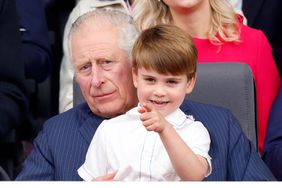 Prince Louis of Cambridge sits on his grandfather Prince Charles, Prince of Wales's lap as they attend the Platinum Pageant on The Mall on June 5, 2022 in London, England.