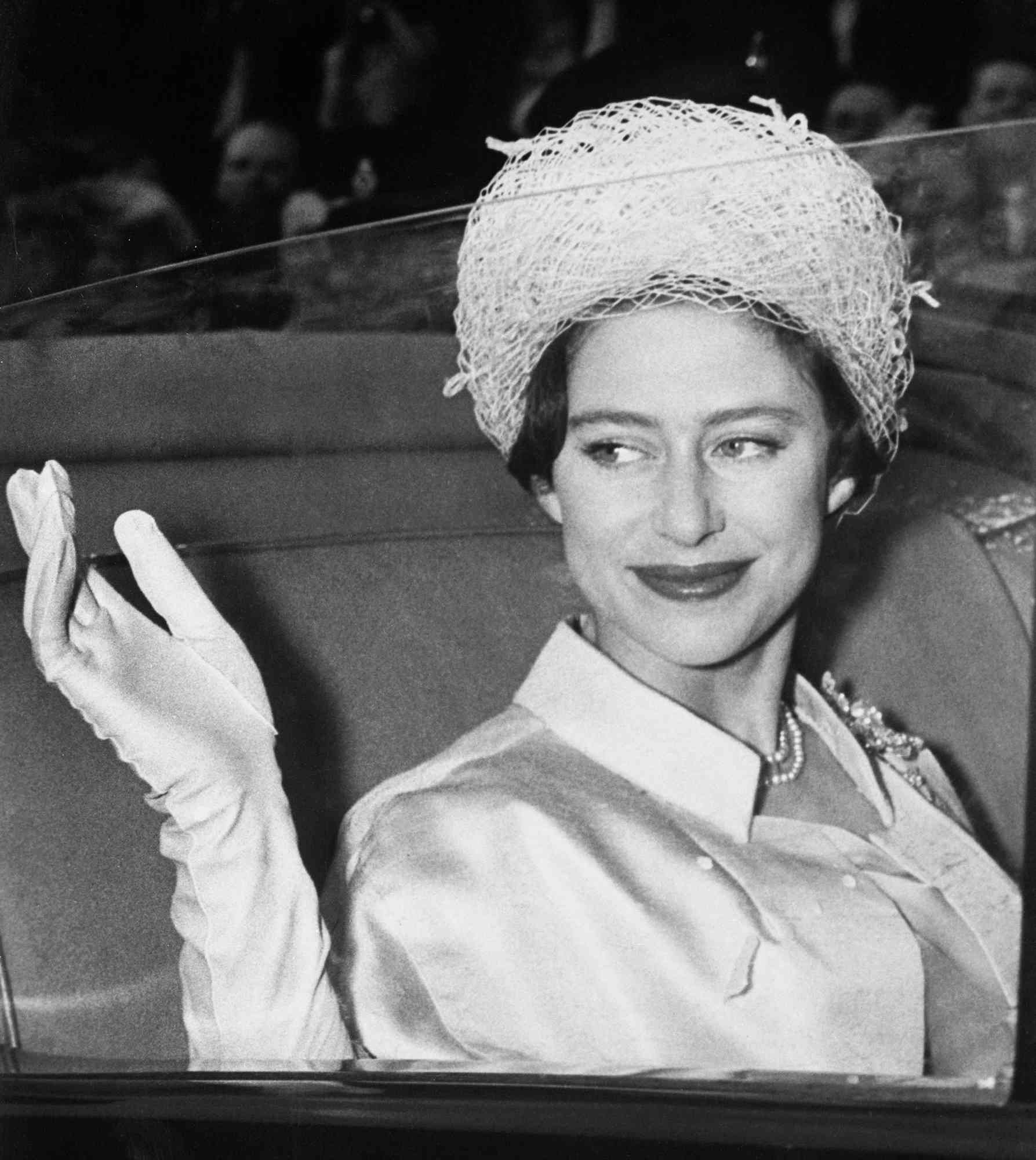 Princess Margaret waves from her coach at Buckingham Palace here May 6th as she leaves on her honeymoon with Antony Armstrong-Jones.