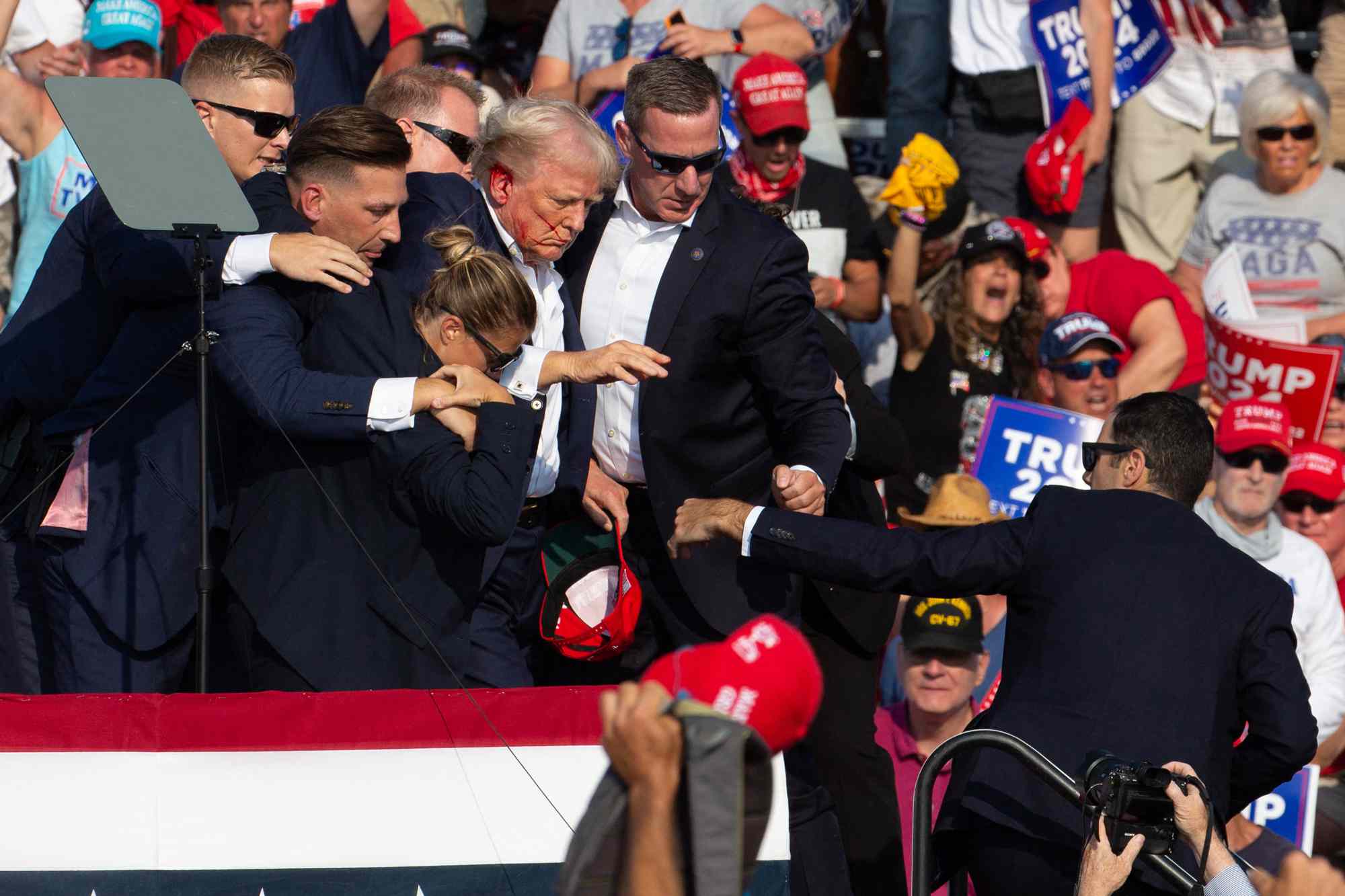 Republican candidate Donald Trump is seen with blood on his face surrounded by secret service agents as he is taken off the stage at a campaign event at Butler Farm Show Inc. in Butler, Pennsylvania, July 13, 2024. 