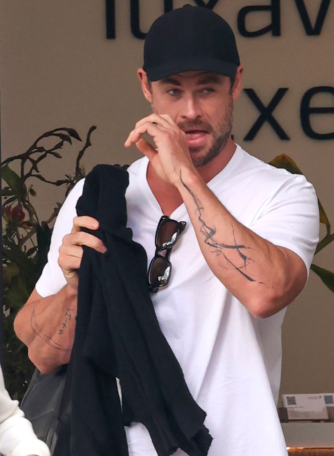 Chris Hemsworth shows off his new abstract arm tattoo when making his way through the airport with his wife Elsa Pataky.