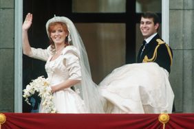 The Duke of York, Andrew, carries Duchess Sarah Ferguson's train as she waves from the balcony on their wedding day.