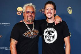 Guy Fieri and his son Hunter Fieri pose on the orange carpet at the grand opening of Guy Fieri's Flavortown Sports Kitchen at Horseshoe Las Vegas on July 07, 2023 in Las Vegas, Nevada.