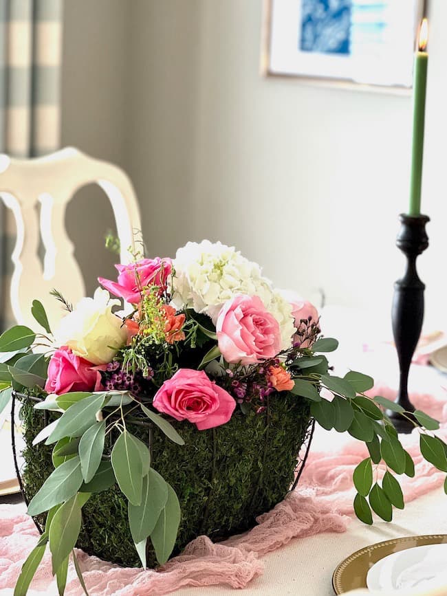 Garden flower shower centerpiece with pink, coral and white flowers, green taper candles and blush cheesecloth table runner