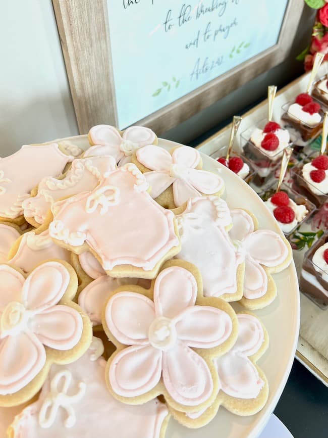 Pink onesie sugar cookies and flower cookies for baby shower