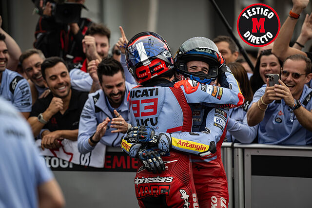 Masini (barba), al fondo, en el abrazo de los M�rquez en Sachsenring.