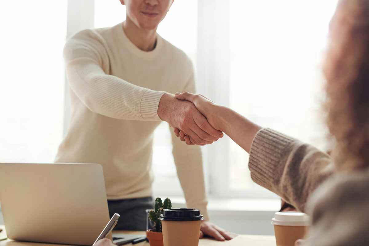 Corretores apertando as mãos celebrando uma parceria de fifty imobiliário