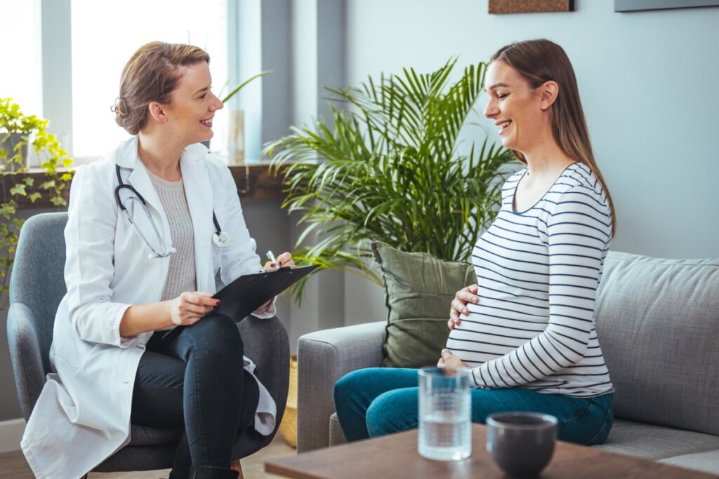 Médica e gestante sentadas conversando