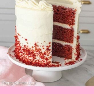 Pinterest graphic of a red velvet cake on a cake stand with a slice cut out.