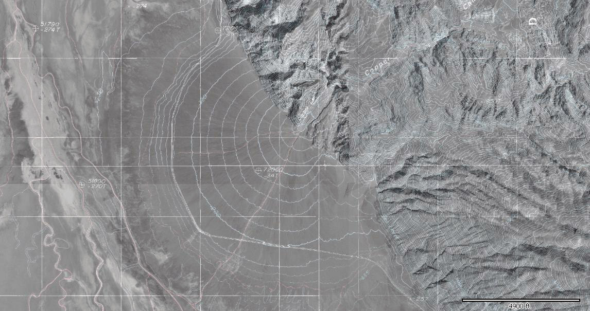 Black and white aerial image with white elevation contour lines overlain on the image. The contour lines show a semi-circular fan-shaped deposit where a stream emerges from a canyon in Death Valley.