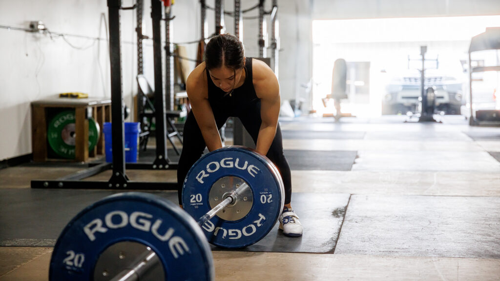 Woman adjusts weights in a gym