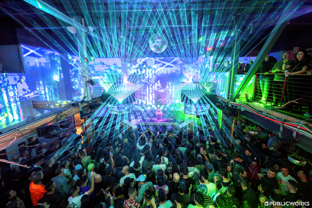 View from the Mezzanine in the Main Room of a blue and green laser light show.